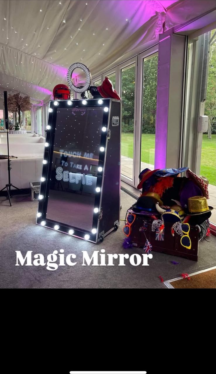 Magic Mirror glowing under purple lighting in a marquee with a props box