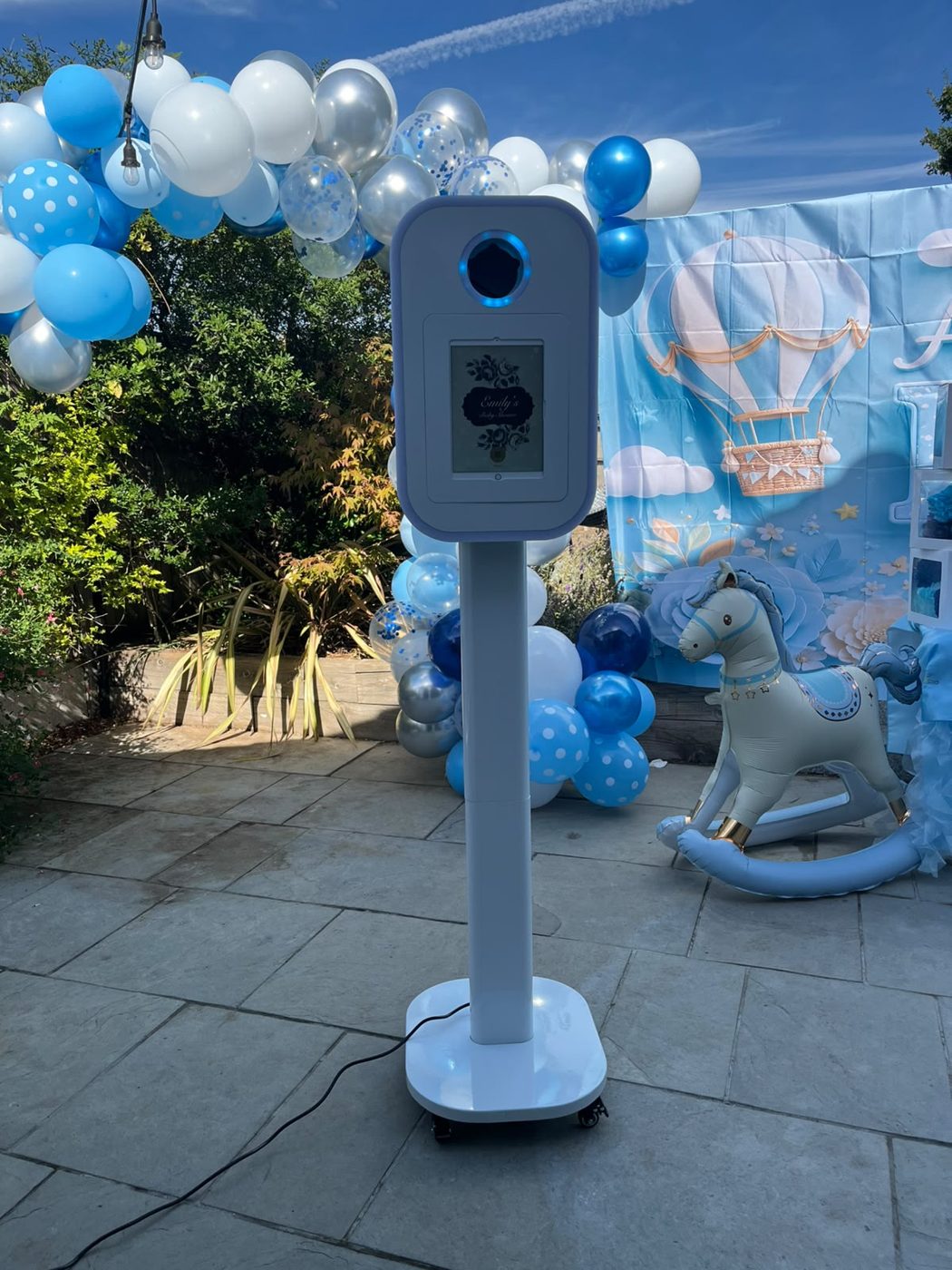 White Photo Pod at a baby shower with blue balloons and a hot air balloon backdrop