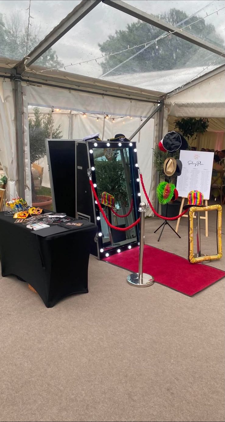 Magic Mirror set up with red carpet and gold frame prop inside a wedding marquee
