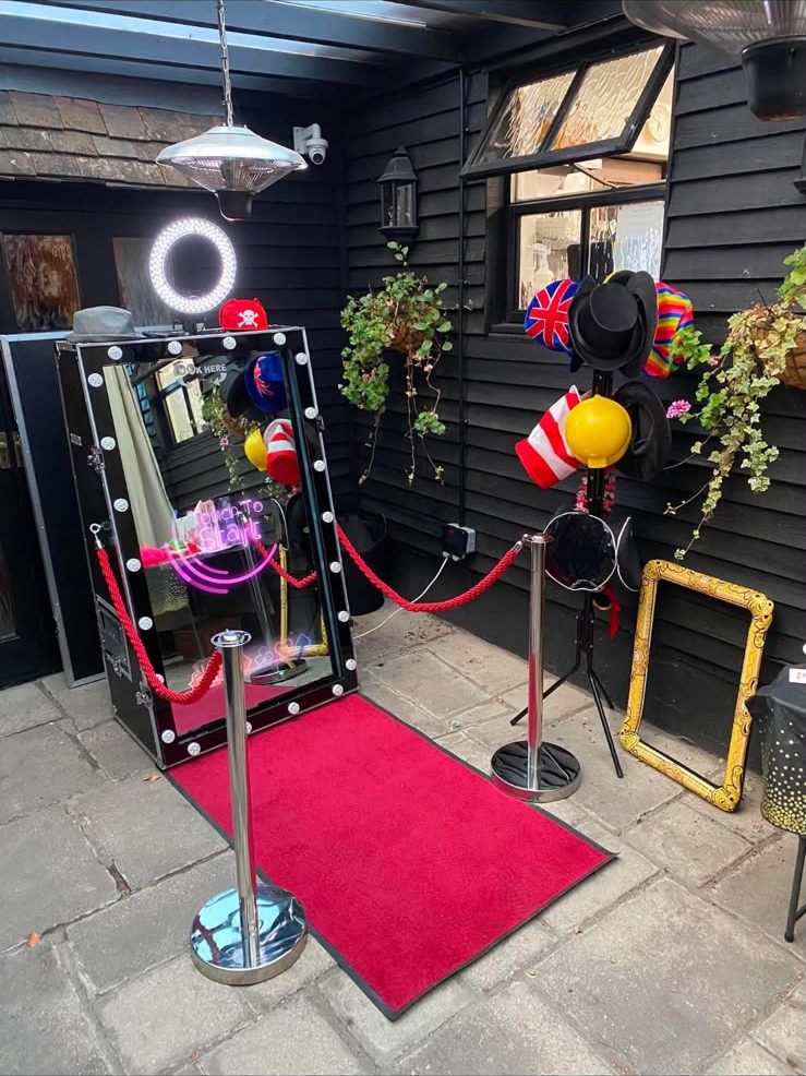 Magic Mirror under a covered courtyard with red rope barriers and props