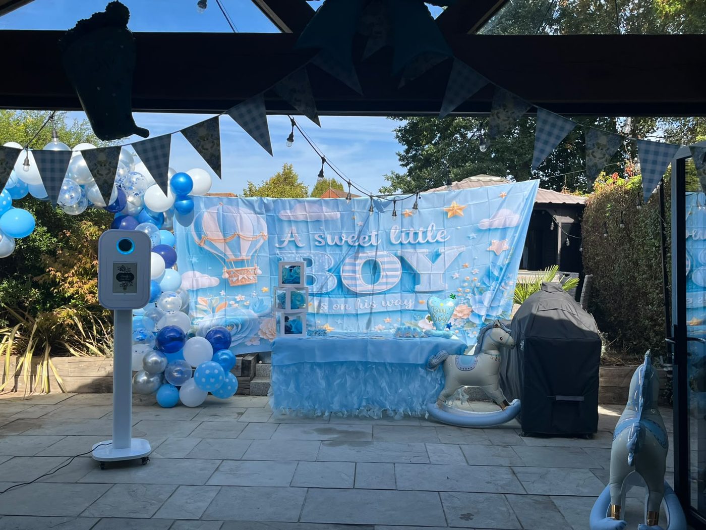 Photo Pod on a garden patio beside a blue baby shower balloon display